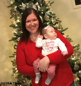 Angie holding Leia in front of a Christmas tree